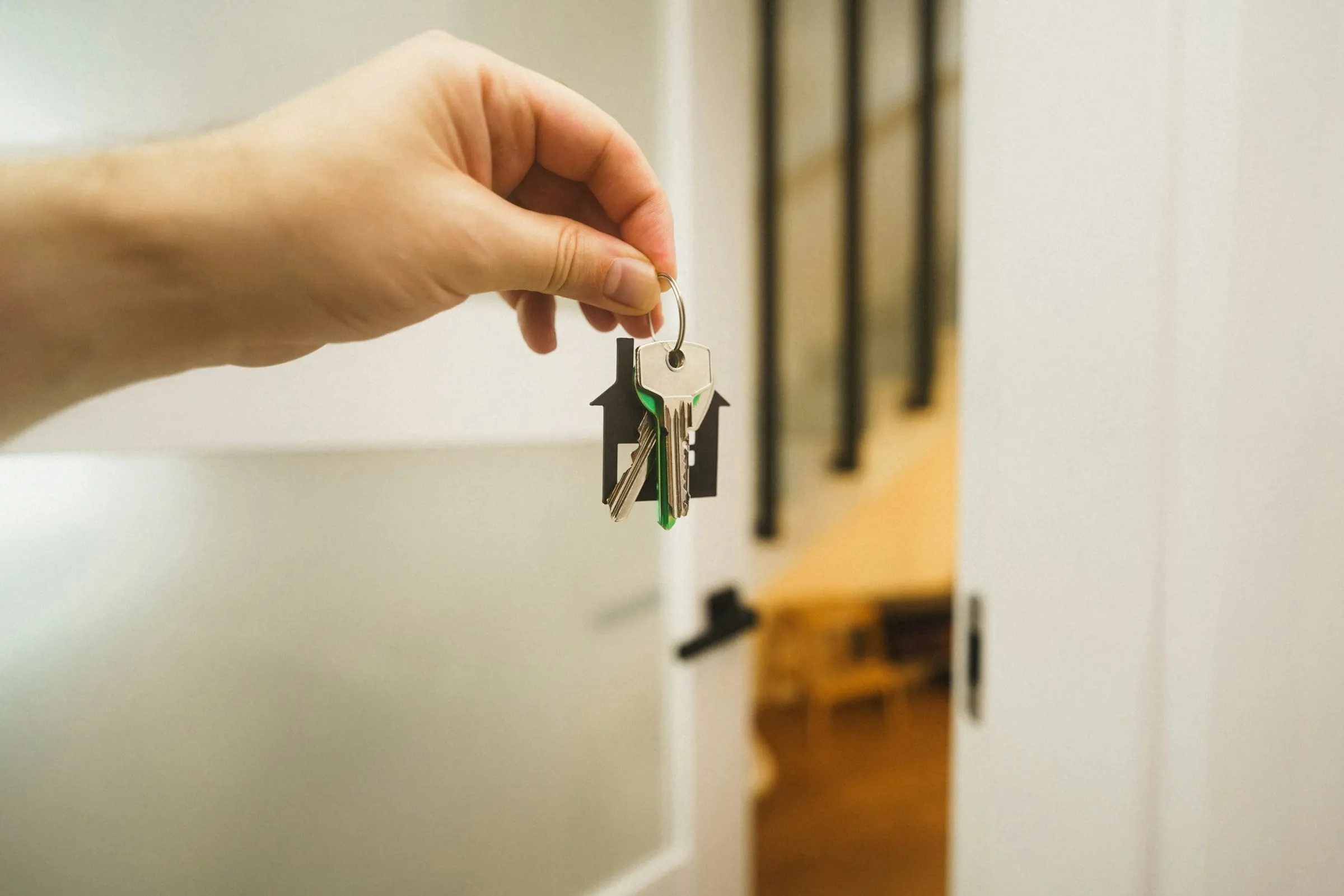 Hand holding a house key at a door